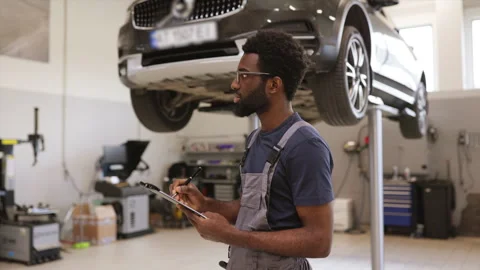 Auto mechanic checking car repair in service workshop Stock Footage 280458389