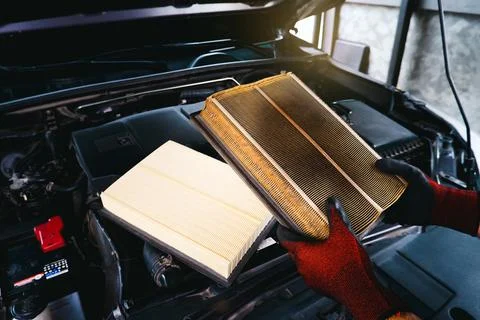 Auto mechanic checking the clogged air filter of a car Stock Photos