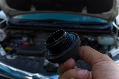 Auto mechanic checking engine oil dipstick in car with oil cap . Auto mechani Stock Photos