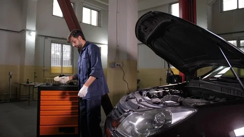 Auto mechanic checking oil level in car engine Stock Footage 123505410