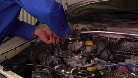 Auto mechanic checks car testing results in garage with tablet in his hands Stock Footage 75686624