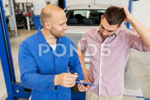 Auto mechanic with clipboard and man at car shop Stock Photos