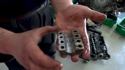 Auto mechanic demonstrates defective engine camshaft bearing and camshaft Stock Footage 169828063