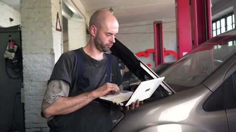 Auto mechanic diagnoses a car using a computer. car workshop Stock Footage 205231602