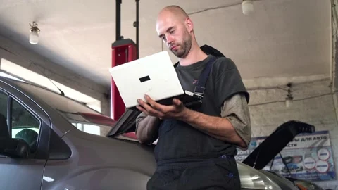 Auto mechanic diagnoses a car using a computer. car workshop 库存影片 205231663