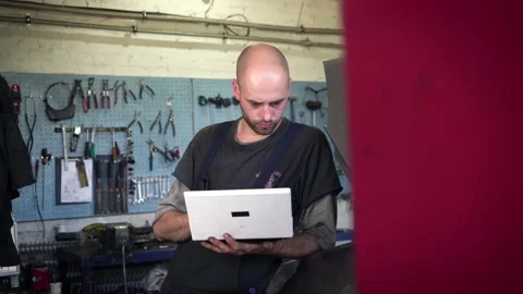 Auto mechanic diagnoses a car using a computer. car workshop 動画素材 207787638