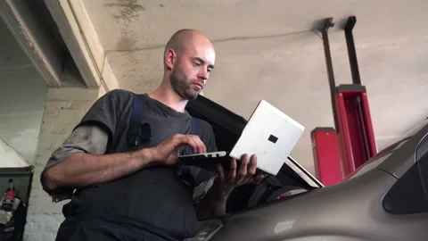Auto mechanic diagnoses a car using a computer. car workshop Vídeos de archivo 207795973