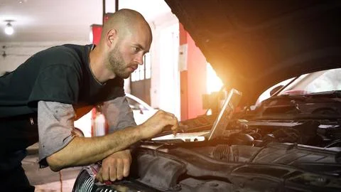 Auto mechanic diagnoses a car using a computer. car workshop. close-up Stock Photos