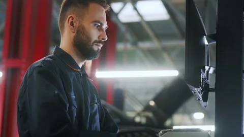 Auto mechanic diagnosing car engine with a laptop with special program Stock Footage 298196965