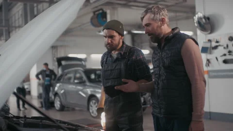Auto Mechanic Diagnosing Problem and Talking to Client Stock Footage 145809290