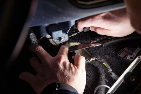 An auto mechanic disassembles a car interior using various trim removal tools Stock Photos