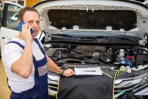 An auto mechanic does maintenance to the car. Foto stock