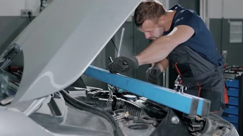 An auto mechanic fixes a gearbox with a safety device, for repairs in a modern Stock Footage 239471775