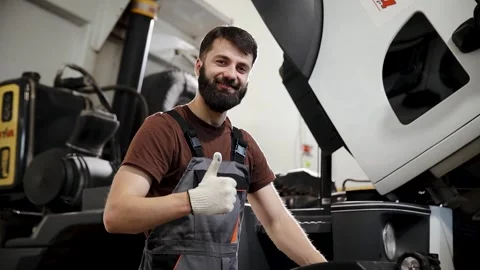 Auto mechanic giving thumbs up, smiling and demonstrating successful repair Stock Footage 333705822