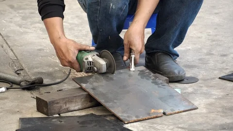 Auto mechanic hand using angle grinder cutting steel plate in auto repair garage Stock-Footage 124282317