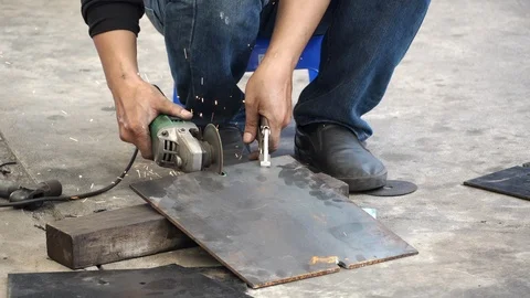 Auto mechanic hand using angle grinder cutting steel plate in auto repair garage Stock-Footage 124283674