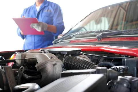 Auto mechanic He notes the defective item of the engine at the maintenance ce Stock Photos