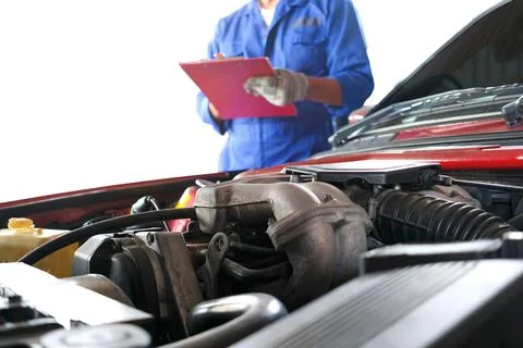 Auto mechanic He notes the defective item of the engine at the maintenance ce Stock Photos