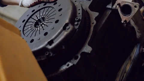 The auto mechanic holds the motor, which is lowered by a mini-crane onto the Stock Footage 77187285
