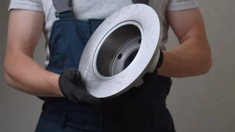 Auto mechanic inspecting new car brake disc rotor Stock Footage 326147045