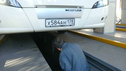An auto mechanic inspects the bus Stockbeeldmateriaal 90036369