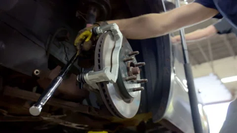 Auto mechanic installing new brake with his tool on a modern vehicle. Close up Stock Footage 311909435