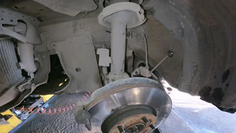 Auto mechanic installing two piston brake calipers and disc brake rotors. Stock Footage 330125047