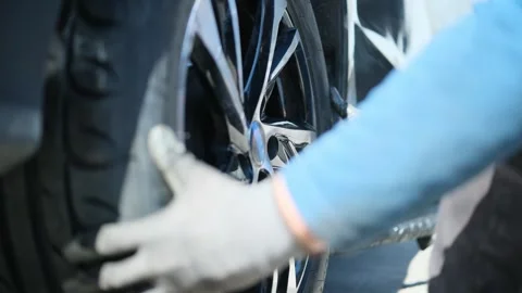 Auto mechanic installing a wheel on a car, close-up Stock Footage 306883247