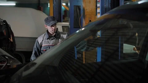 Auto mechanic is lifting up a car, using electro hydraulic lift in an auto Stock-Footage 84132376