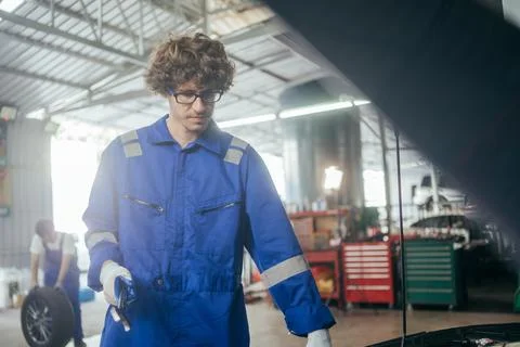 Auto mechanic man checking and repairing car at repair shop Stock Photos