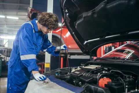 Auto mechanic man checking and repairing car at repair shop Stock Photos