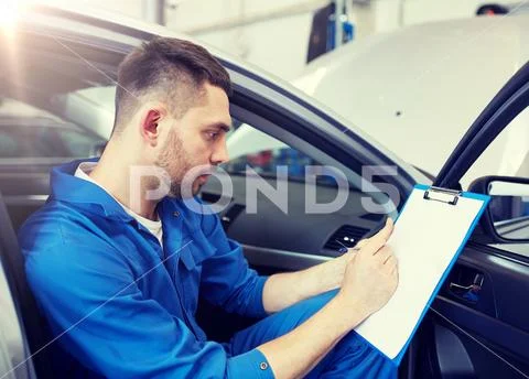 Auto mechanic man with clipboard at car workshop Stock Photos