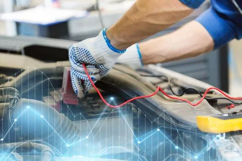 Auto mechanic man with multimeter testing battery Stock Photos