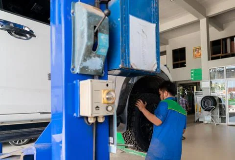 Auto mechanic man replace a new tire in garage. Foto stock
