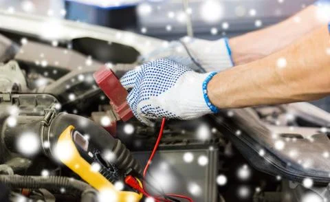 Auto mechanic with multimeter testing battery Stock Photos