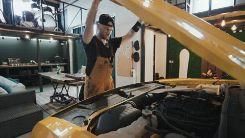 Auto Mechanic Opening Yellow Motor Hood, Lightning It With Torch Stock Footage 238841695