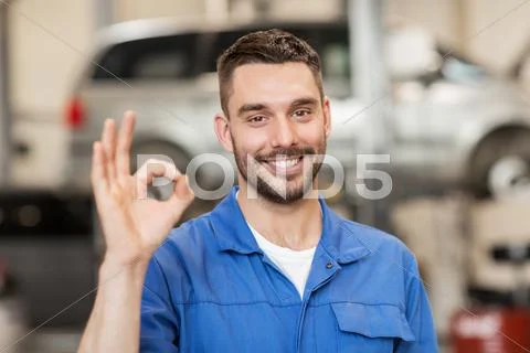 Auto mechanic or smith showing ok at car workshop Stock Photos