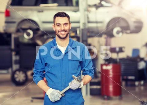 Auto mechanic or smith with wrench at car workshop Stock Photos