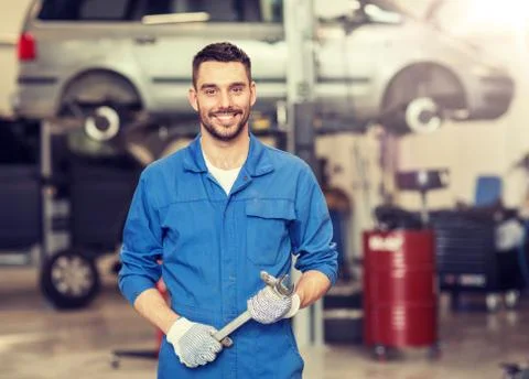 Auto mechanic or smith with wrench at car workshop Stock Photos