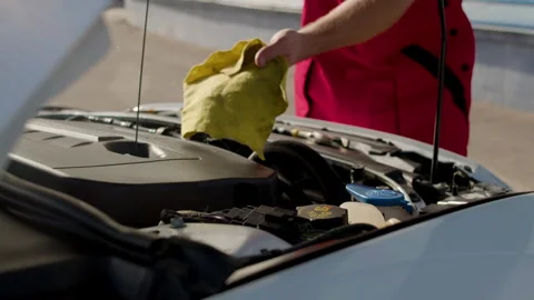 Auto mechanic performing under-the-hood check, inspecting engine and fluid Vídeos de archivo 312516844