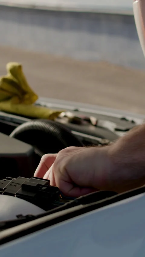 Auto mechanic performing under-the-hood check, inspecting engine components and Stock Footage 320393891