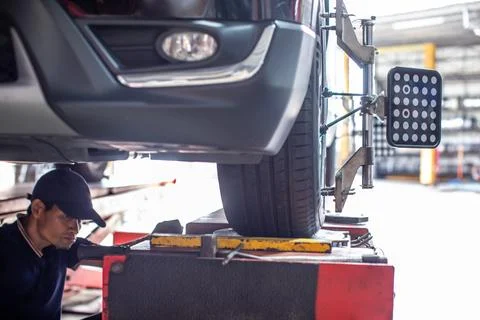 Auto Mechanic Performing Wheel Alignment and Suspension Service in Auto Rep.. Stock Photos