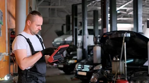 Auto Mechanic performs computer diagnostics of cars in a special form. Car Stock Footage 244715895