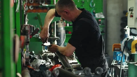 An auto mechanic performs maintenance and repair of a driveshaft in a car repair Stock Footage 281581596