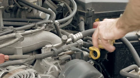 Auto mechanic pours additional motor engine oil Stock Footage 63624150