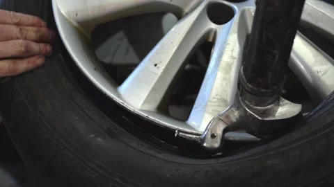 Auto mechanic puts a new tire on a car disc using a tire fitting machine Stock Footage 169944752