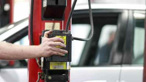 Auto Mechanic Raising a Car on Platform Stock Footage 244360582