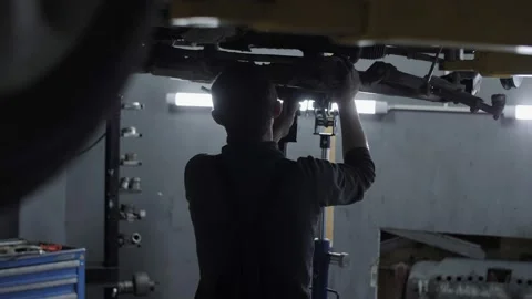 Auto mechanic removes the part from the bottom of the car Stock Footage 194844874
