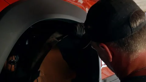 The auto mechanic removes the plastic spacers for the front arches of the car Vídeos de archivo 248165997