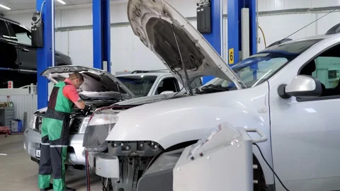Auto mechanic repair something under the hood of the car at service station Stock Footage 135451333